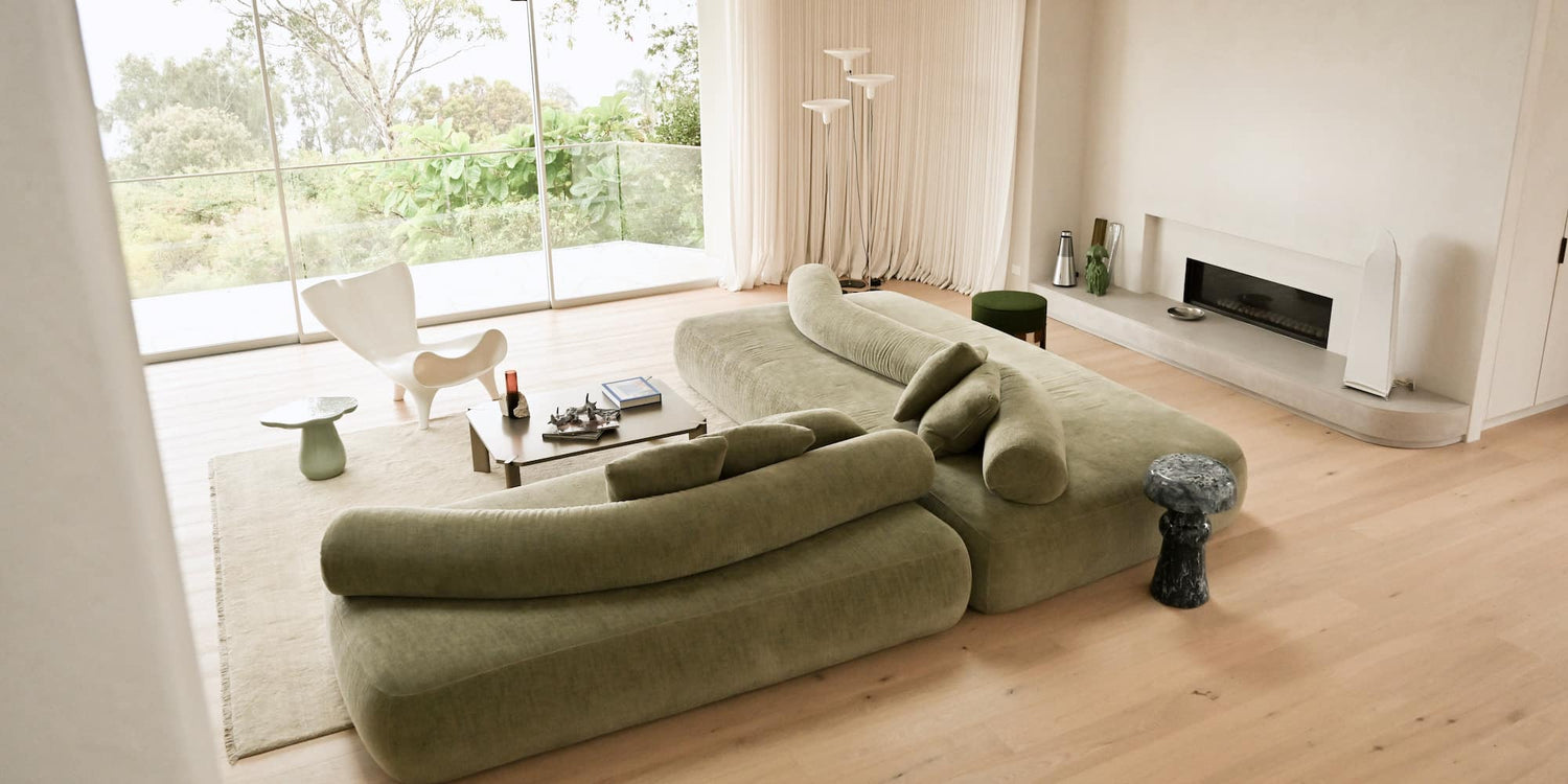 Modern living room with a green sofa and coffee table.