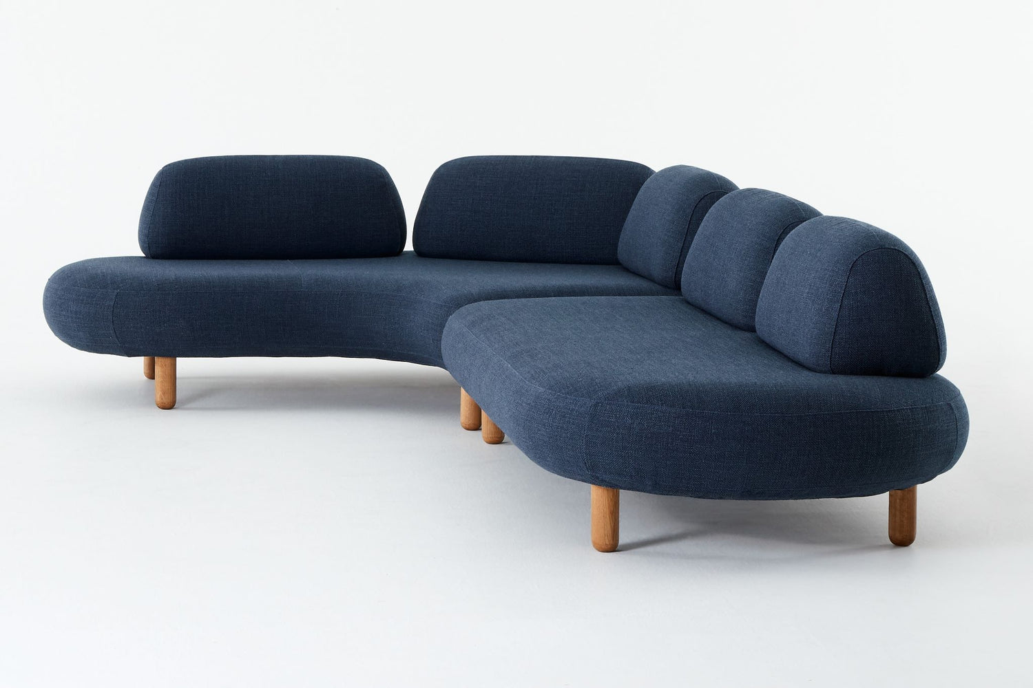 Ethos Max blue sofa setting with one curved module and one straight module with round ends, seen from the side.