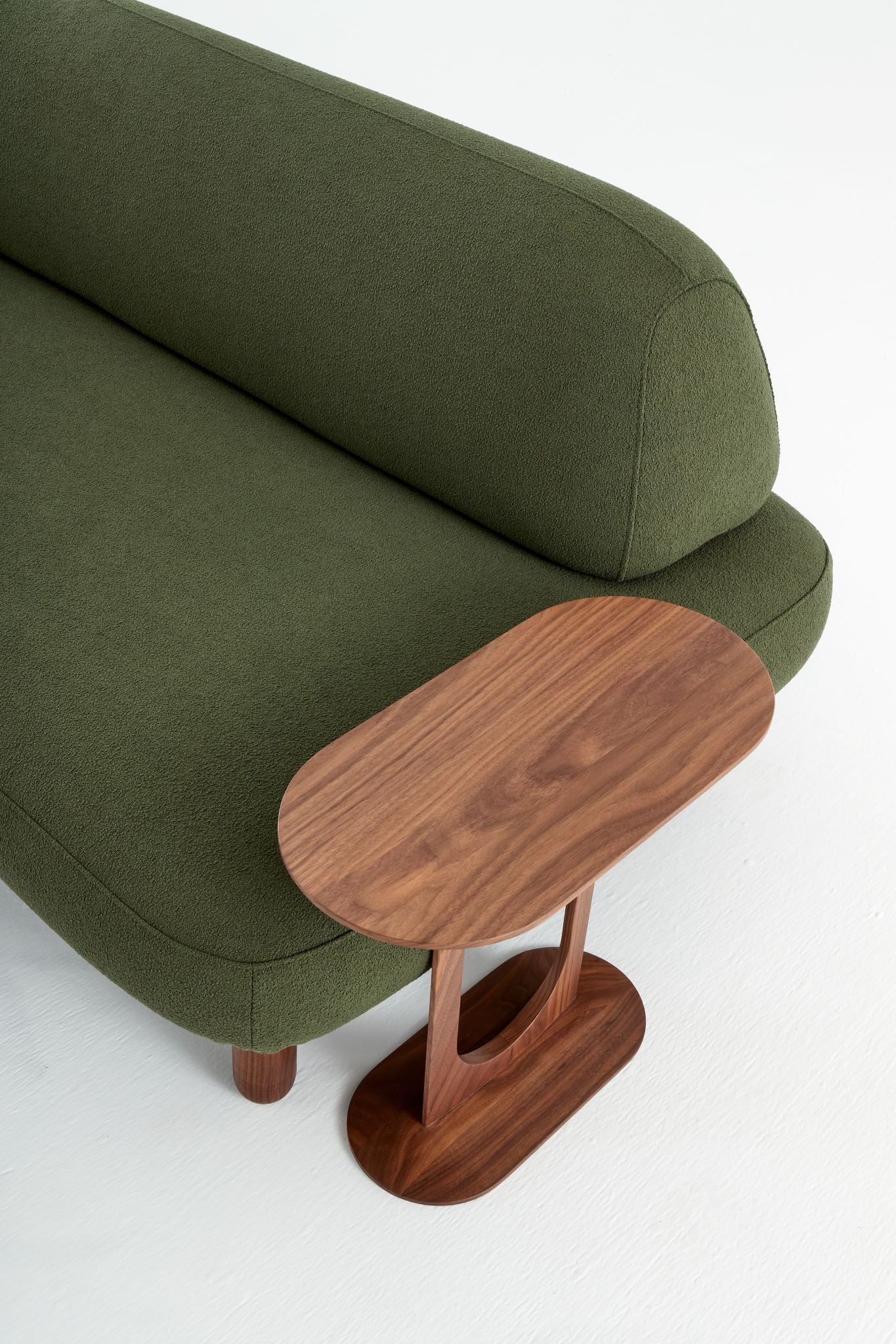 Ethos side table in solid walnut at the side of a green Ethos Plus sofa