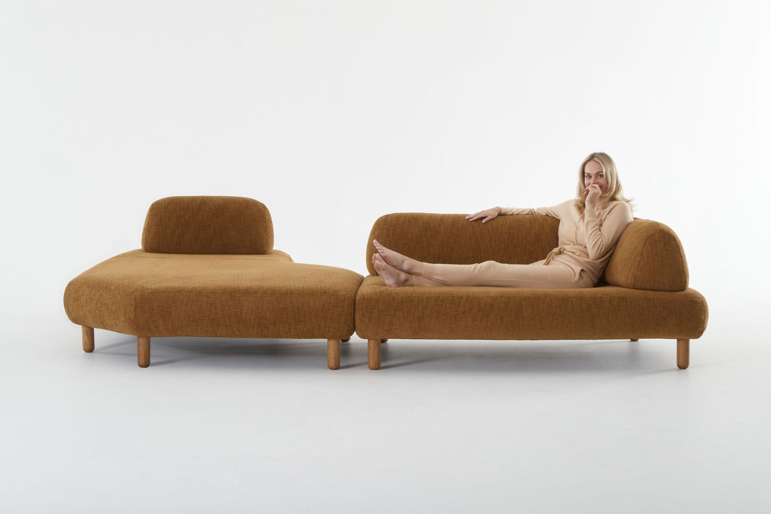 Locus modular sofa in burnt orange with woman reclining and smiling.