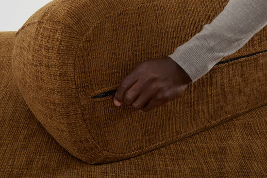 Unzipping a removable cover from the moveable sofa back.