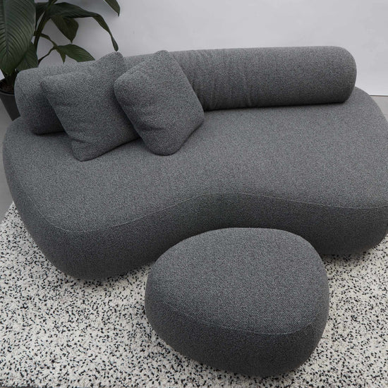 Rolly designer sofa with moveable back roll, ottoman and cushions in grey.