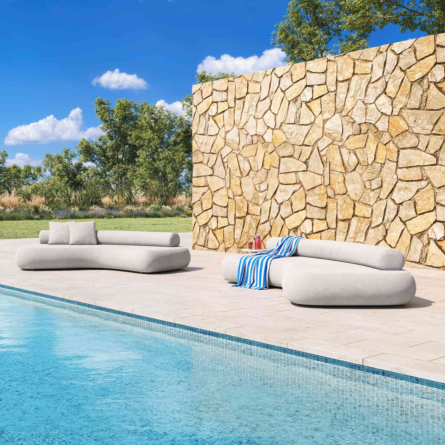 Two 3.5metre Outdoor Rolly lounges next to an Australian backyard pool, with a sandstone wall behind and grass and trees in the background.