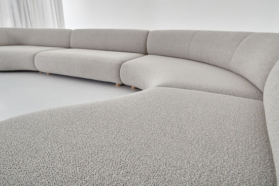 Eclipse expansive modular sofa setting with straight and curved sofa modules, viewed from the right hand side. 