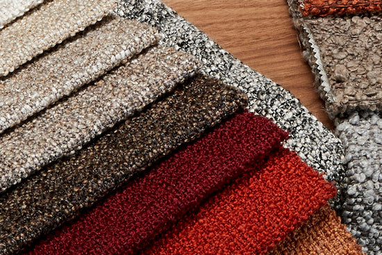 Fabric swatches with reds and browns shown on a timber table