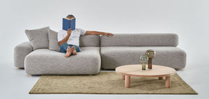 Flux modular sofa with chaise and sofa pieces and man reading stretched out on chaise.