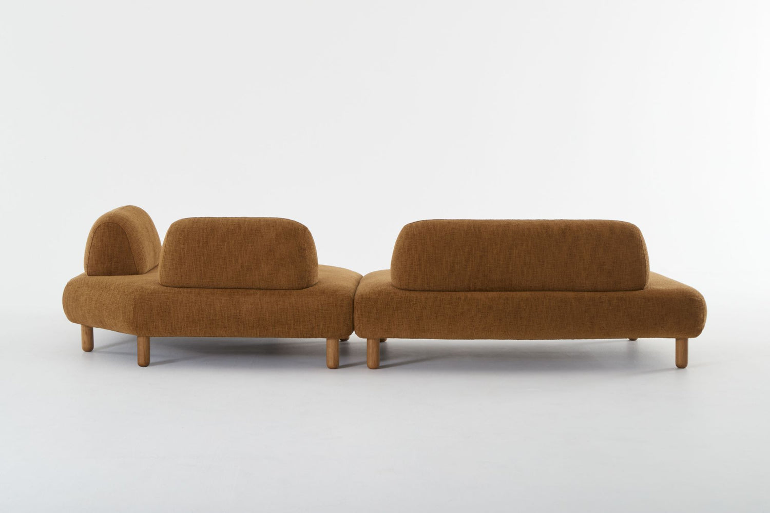 Two modules of the Locus sofa in burnt sienna viewed from the back.