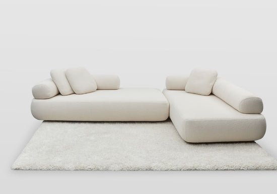 The Newman designer sofa and chaise showing the back rolls swapped and re-arranged. Shown in white boucle