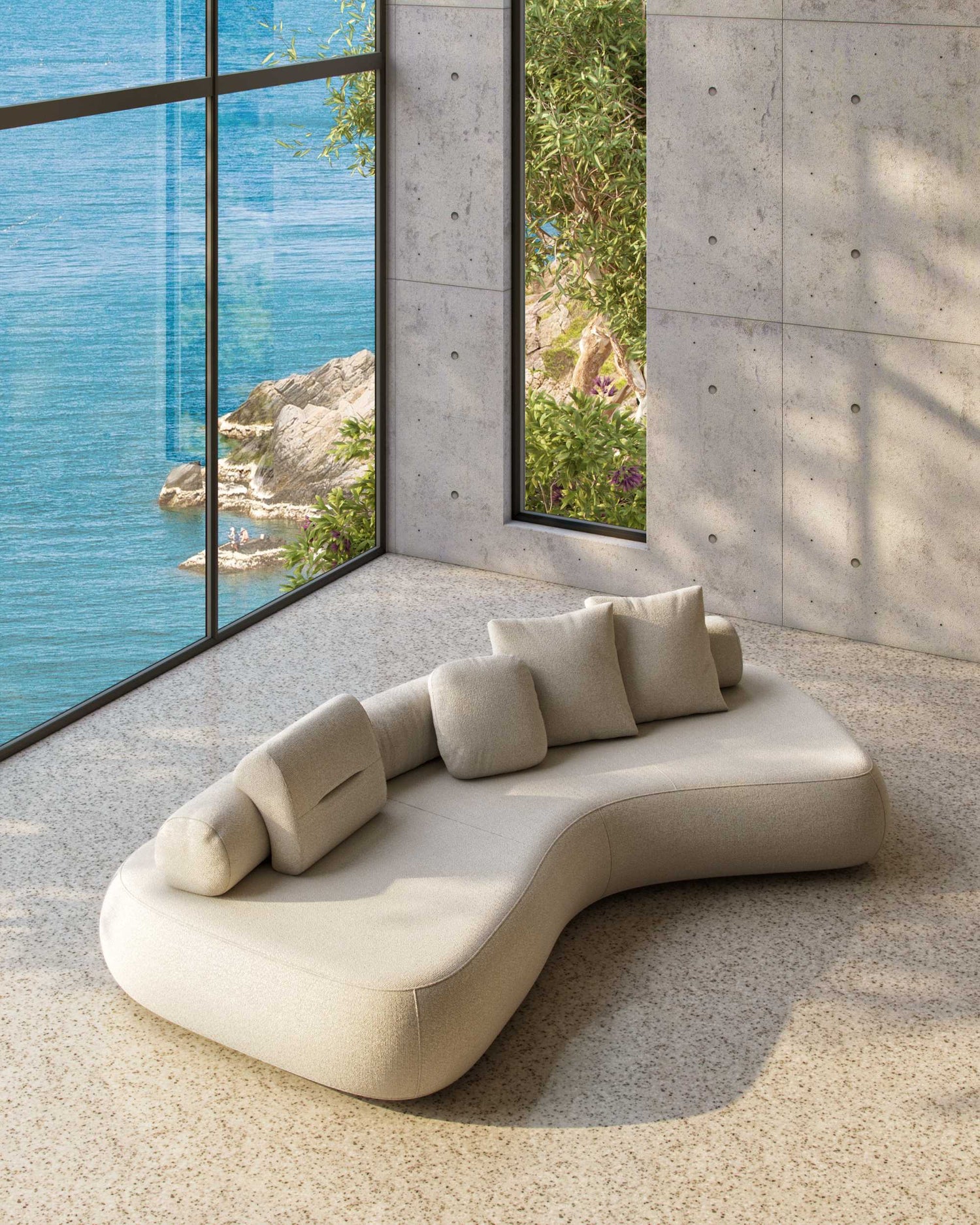 The 3.5 metre Rolly designer sofa shown on in a room with concrete walls, terazzo floor and with an ocean view through large windows.