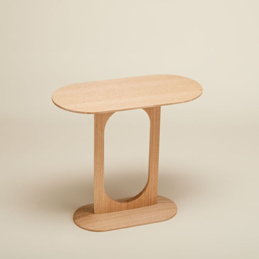 A rounded oblong side table made of Tasmanian oak with a smooth finish and rounded edges, displayed against a neutral background.